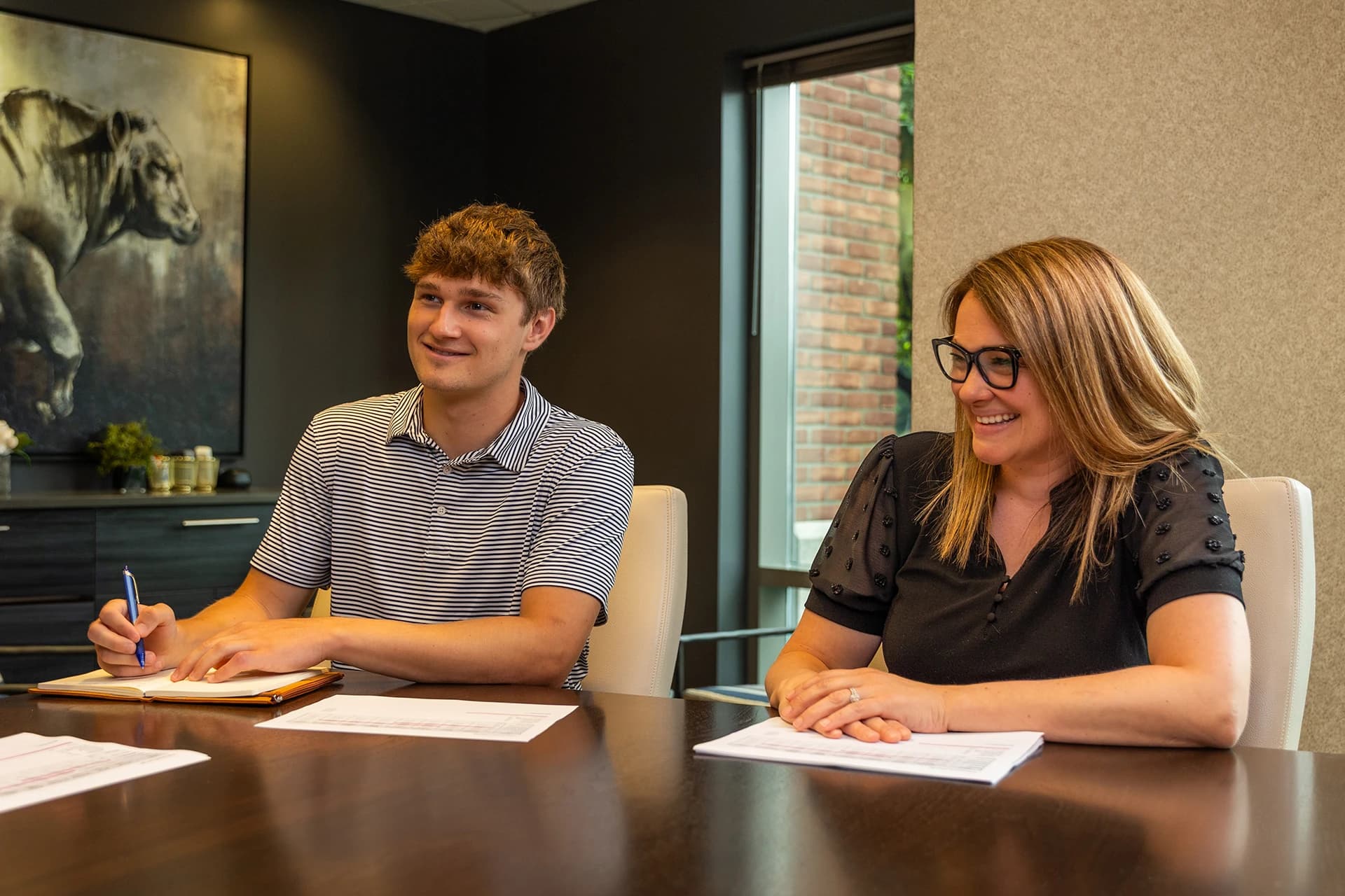 A young man and woman sitting at a table in a conference room